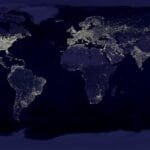 Satellite view of Earth at night with illuminated cities across continents.